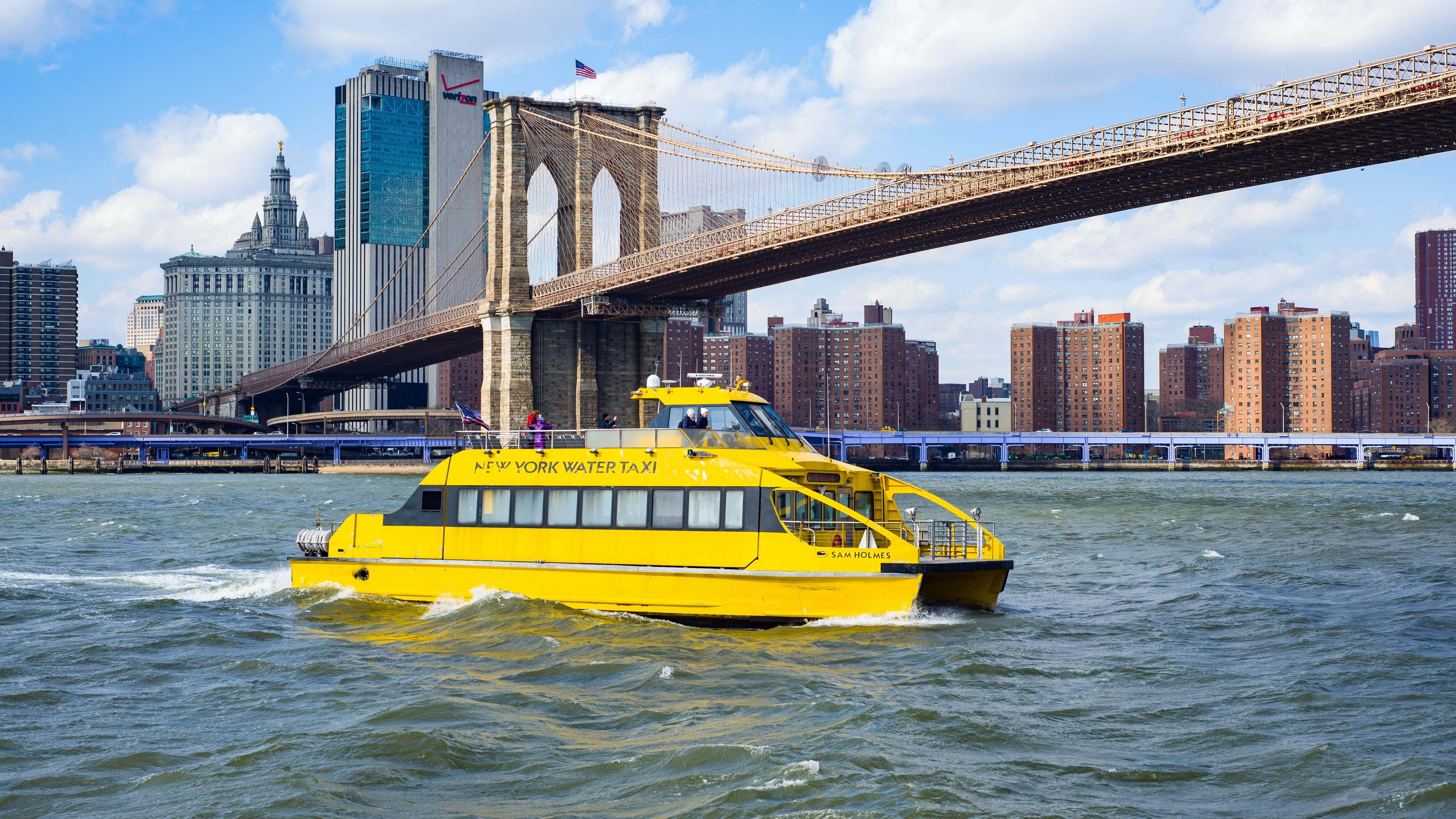 Reference input: a yellow boat is cruising in front of a bridge